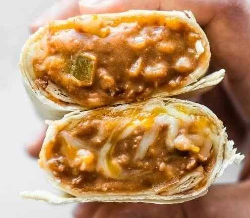 A delicious plate of homemade Bean and Cheese Burritos garnished with fresh toppings.