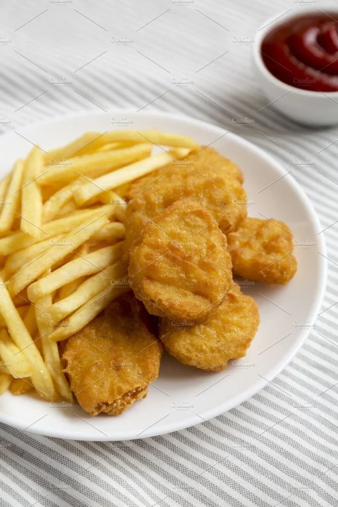 Delicious chicken nuggets served with crispy French fries on a plate