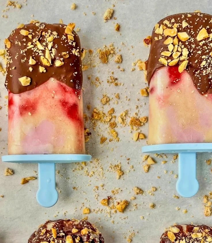 Banana split frozen yogurt popsicles served on a plate with toppings