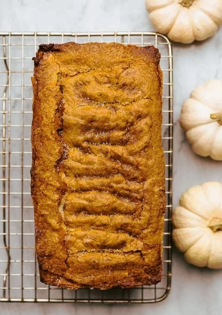 Slice of cream cheese pumpkin bread topped with cream cheese frosting