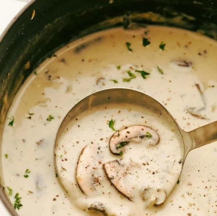 Creamy mushroom soup garnished with herbs in a bowl