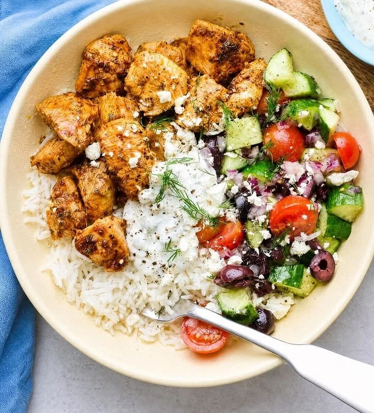 Delicious Greek Chicken Bowl topped with fresh vegetables and tzatziki sauce