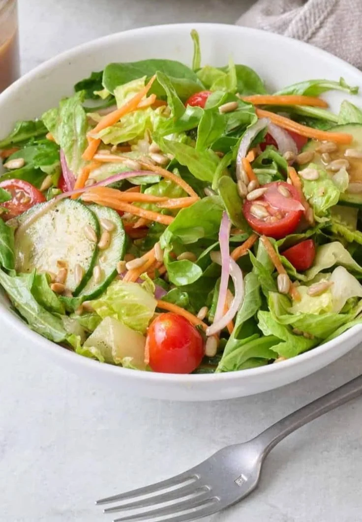 Fresh easy mixed greens salad with colorful vegetables and dressing