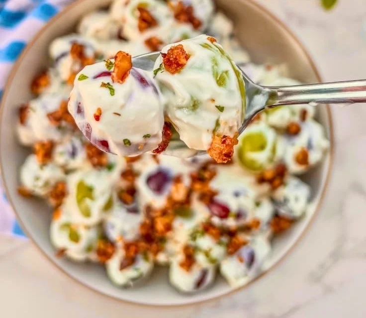 Grape salad with candied walnuts on a white plate