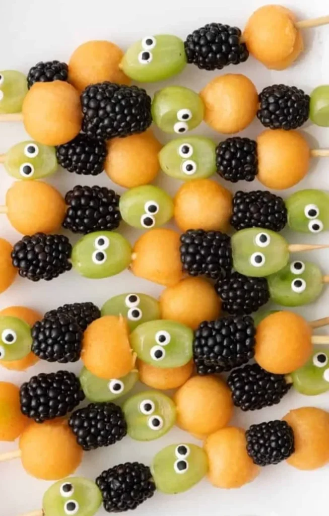 Colorful Halloween fruit skewers with spooky designs for a festive treat