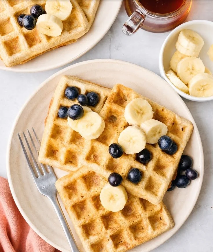 Delicious homemade oatmeal waffles topped with fresh fruits and syrup