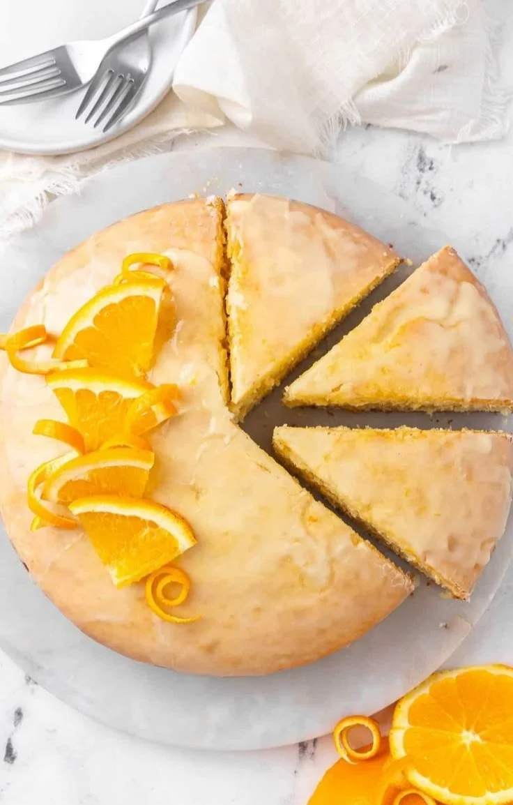 Delicious homemade orange cake topped with orange slices and icing