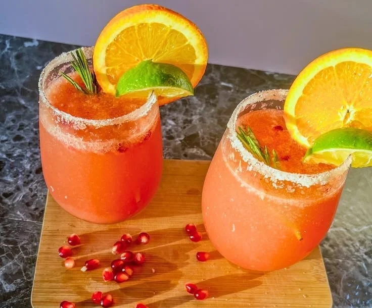 Pomegranate Mimosa cocktail in a glass garnished with pomegranate seeds