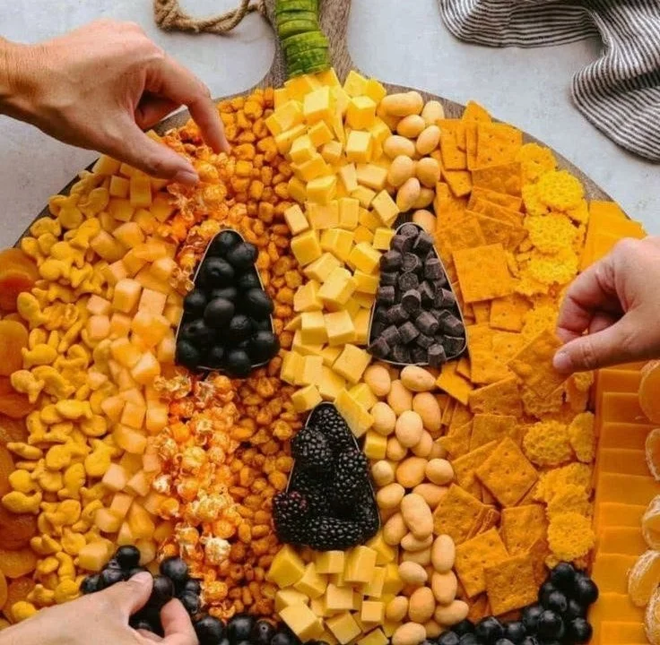 A beautifully arranged pumpkin charcuterie board with seasonal treats.