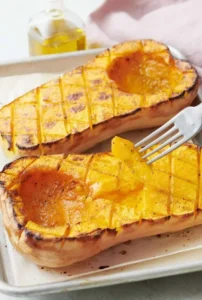 A beautifully roasted butternut squash dish garnished with herbs.