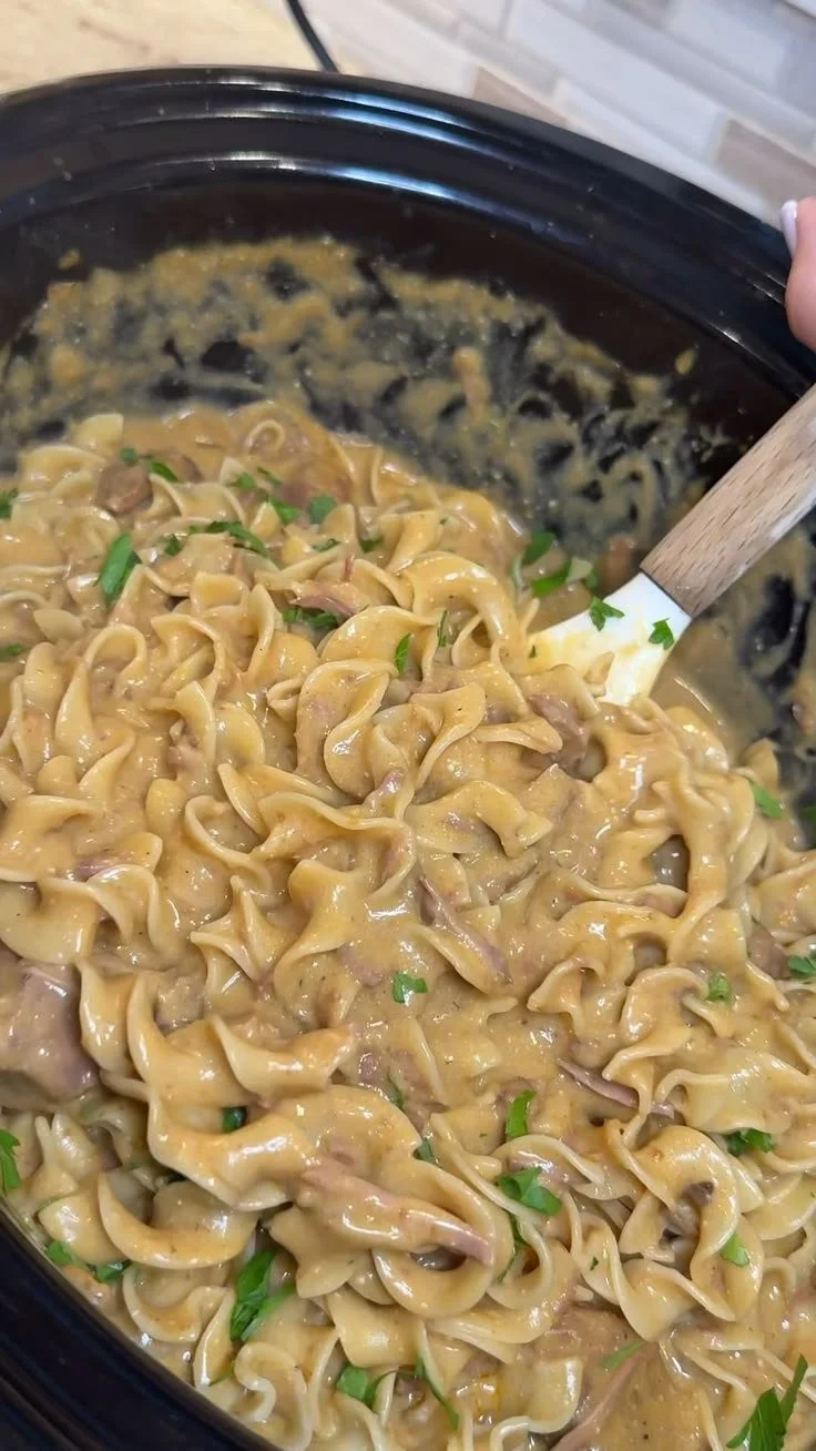 Bowl of Slow Cooker Golden Beef and Noodles garnished with herbs